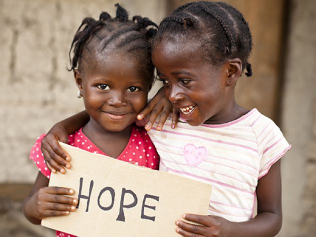 Due bambine africane mostrano un cartello che invita alla speranza.