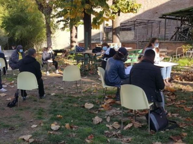 Alcuni studenti del corso di lingua italiana per stranieri seguono la lezione nel giardino interno dell'Antoniano di Bologna, in via Jacopo della Lana.
