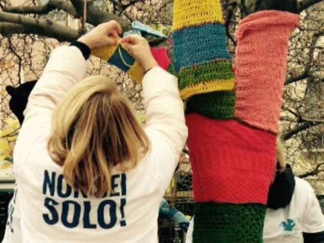 Alcune volontarie della De Leo Fund Onlus preparano un'installazione di «tree knitting» a Padova.