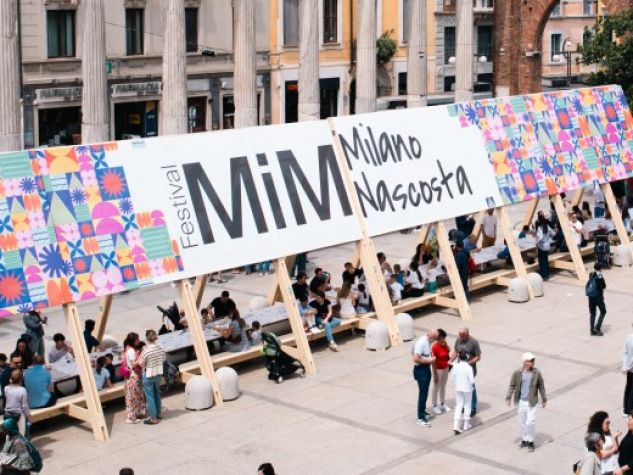 Cartellone del Festival Mim Fiorire a Milano nella piazza delle Colonne di san Lorenzo.