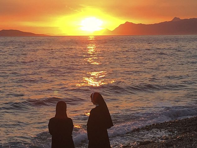 Due suore pregano al tramonto.