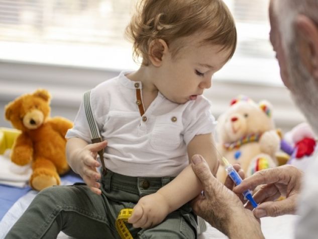 Bambino riceve una dose di vaccino da un medico.