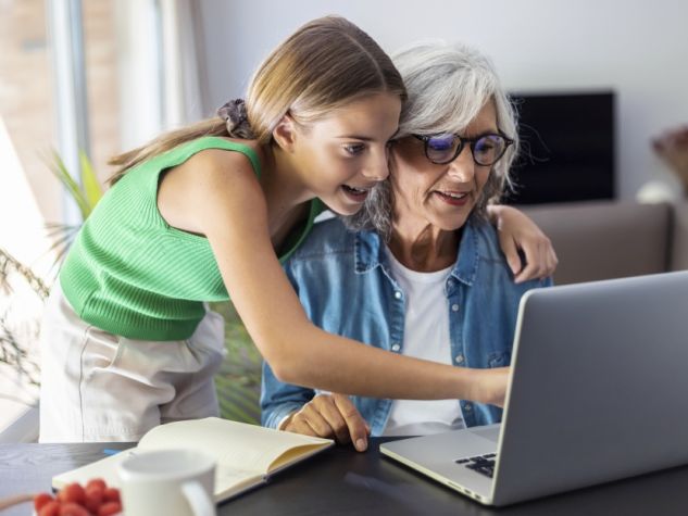 Nipotina insegna alla nonna a usare il computer.