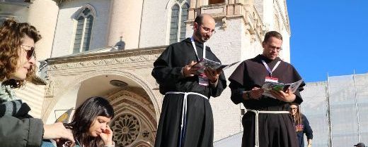  Assisi: due frati con un gruppo di giovani