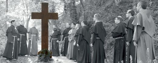 gruppo di giovani frati davanti a un crocifisso