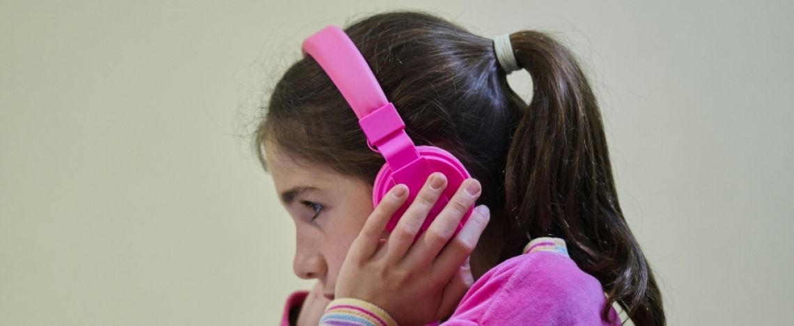 Una bambina completamente rapita dall'ascolto di una storia in cuffia. Una bambina completamente rapita dall'ascolto di una storia in cuffia.