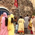 Prima di entrare in chiesa, i fedeli si fermano a pregare alla grotta della Madonna - Suleman Nazir