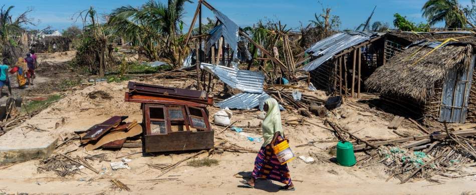 Una donna attraversa il villaggio mozambicano di Guludo, distrutto da un ciclone.
