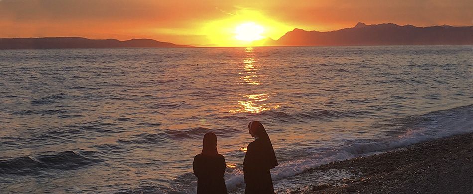 Due suore pregano al tramonto.