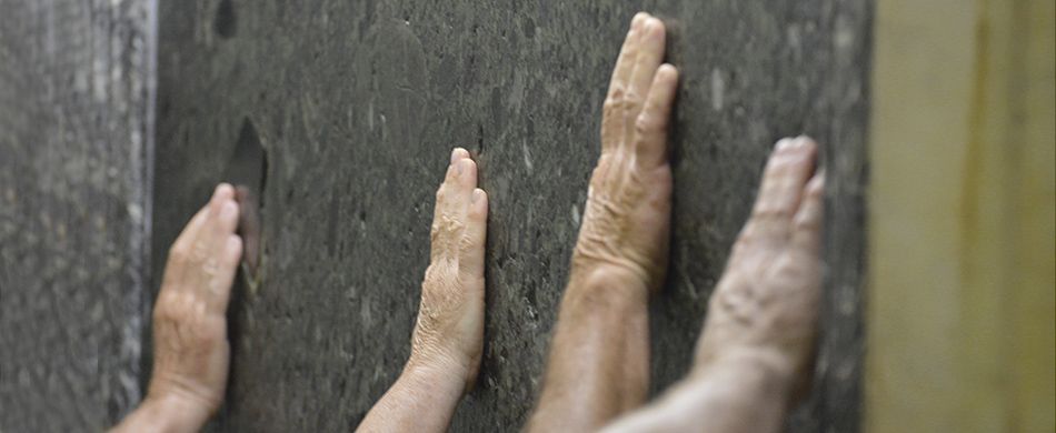 mani che si posano sulla lastra di marmo alla tomba del Santo