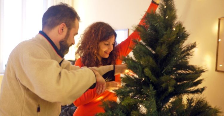 una famiglia prepara l'albero di Natale