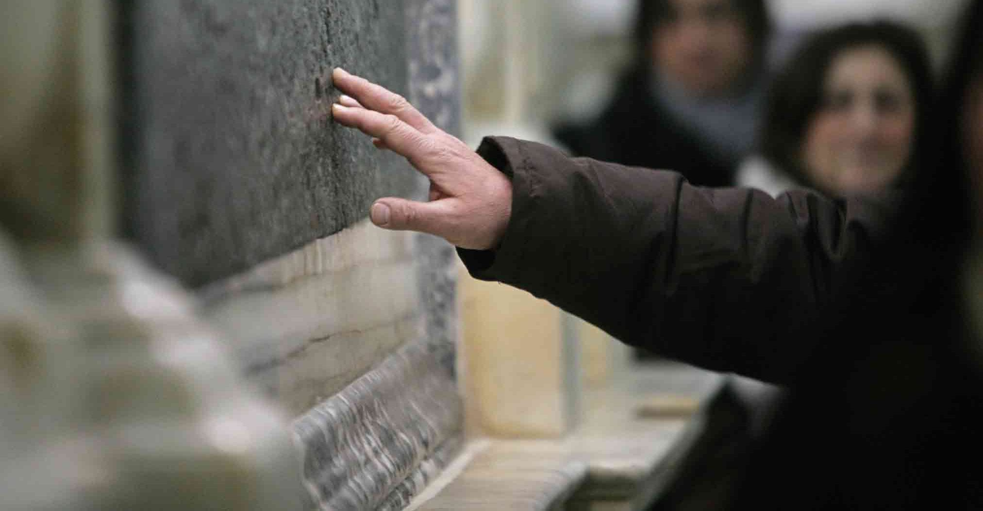 La mano di una devota posata sulla lastra della tomba di sant'Antonio