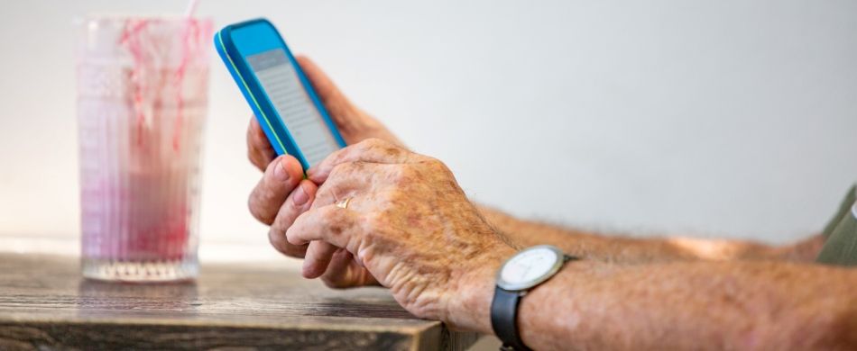 Mani di persona anziana con smartphone