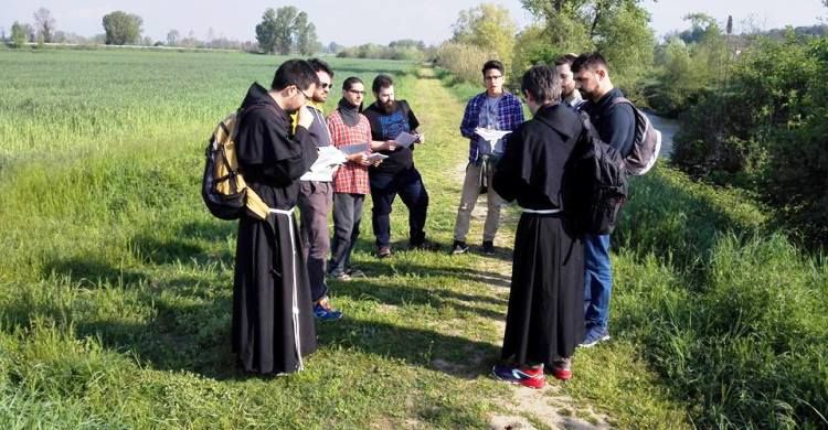 frati e giovani in cammino vocazionale in un momento di preghiera in campagna
